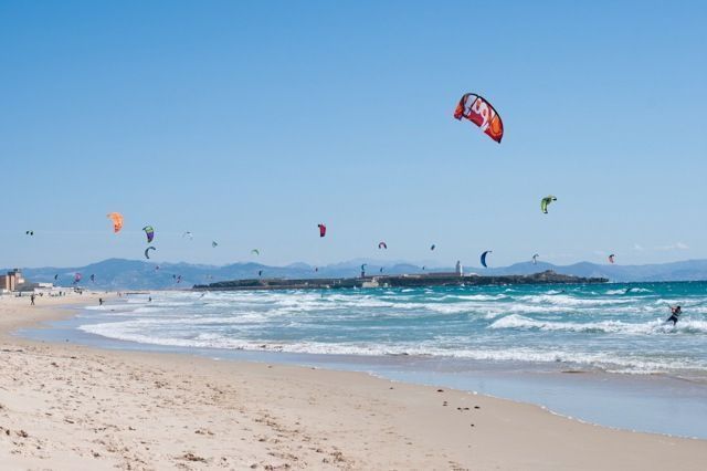 Gracias a los que practican kitesurf, el cielo parece llenarse de pájaros de colores sobrevolando el mar.